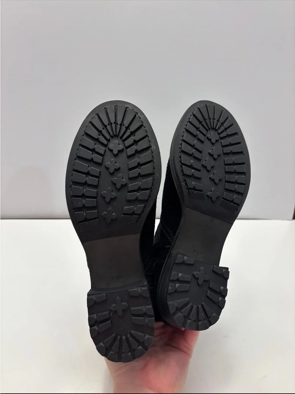 Tory Burch black suede Eloise flat booties with a prominent gold-tone metal logo
